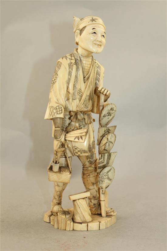 A Japanese sectional walrus ivory figure of a fan seller, early 20th century, 27.5cm
